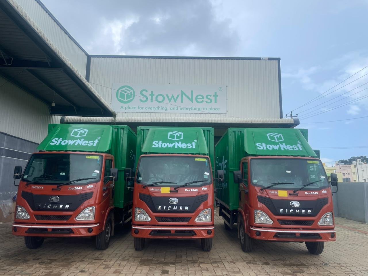 StowNest branded delivery trucks parked outside a StowFlex warehouse facility